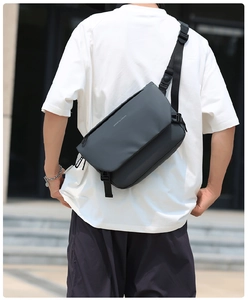 Detail of grey waterproof messenger bag with move to future print on outdoor model