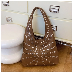 Detail einer braunen Retro-Hobo-Tasche mit silbernen Nieten auf weichem Kunstleder
