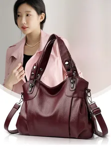 Detail of burgundy pebbled leather tote with silver hardware and adjustable shoulder strap