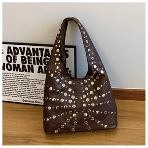 Detail einer dunkelbraunen Hobo-Tasche mit silbernen Metallnieten auf Leder-Oberfläche