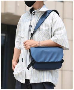 Detail of dark blue messenger bag with 'move to future' text and side buckle closure