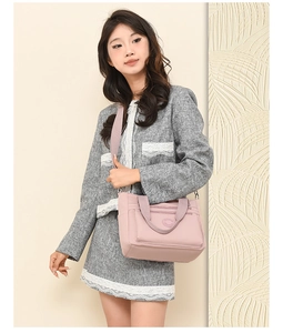 Pale pink nylon tote with double front zippers and wide straps worn by a model