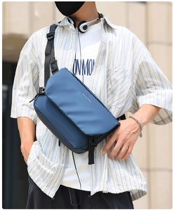 Detail of dark blue messenger bag with adjustable buckle strap and waterproof fabric surface