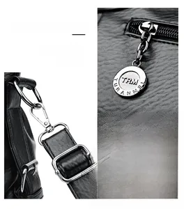Detail of black lychee grain leather handbag featuring silver metal zipper and removable strap
