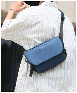 Man wearing a navy blue waterproof messenger bag with adjustable strap in a street scene