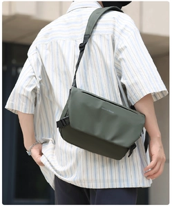 Detail of dark green messenger bag with matte waterproof coating and move to future print