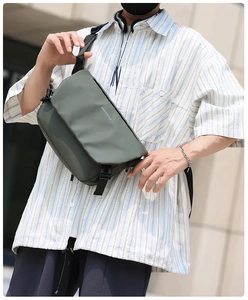 Outdoor shot of army green crossbody bag with black buckle and adjustable strap