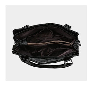 Top-down macro view of the black leather shoulder bag's multi-pocket interior storage