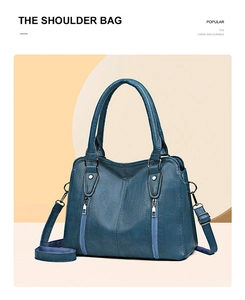 Detail of blue pebbled leather shoulder bag with vertical zipper and top handle