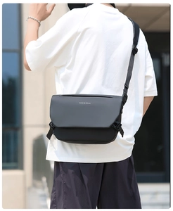 Close-up of matte black messenger bag featuring 'move to future' text and buckle detail