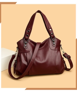 Detail view of burgundy tote bag with litchi grain texture and adjustable shoulder strap