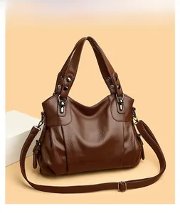 Close-up of brown litchi pattern PU leather handbag with elegant pleats and shoulder strap