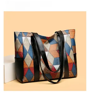Detail of multi-color geometric patchwork on large PU leather tote bag for women