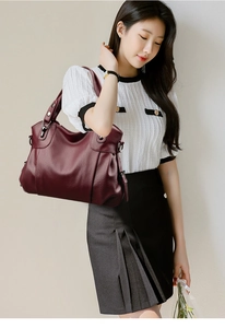 Detail of burgundy PU leather tote bag showing lychee grain texture and silver hardware