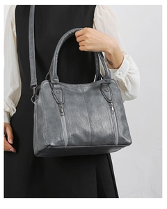 Macro shot of grey pebbled faux leather texture and silver vertical zipper detail