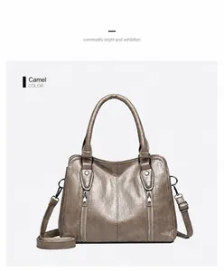 Detail view of camel shoulder bag with vertical zippers and adjustable strap