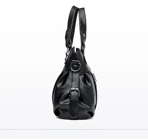 Close-up of black leather bag featuring pleated side design and silver metal D-ring details
