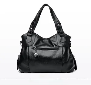 Close-up of black lychee grain PU leather handbag showing rear zipper and TRM metal tag