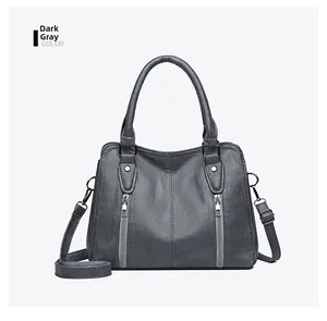 Detail view of dark grey PU leather tote with vertical zippers and silver hardware