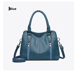 Detail view of blue textured faux leather handbag with silver zippers and round handles