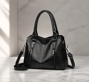 Macro side view of black faux leather handbag with silver zippers and荔枝 grain texture