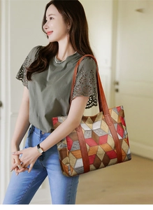 Model wearing a large tote bag with colorful geometric patterns and brown leather handles