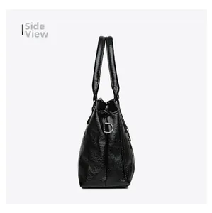 Side view detail of a black leather handbag with smooth texture and metal D-rings