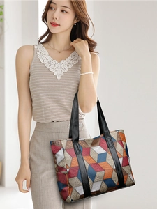 Model showing a large colorful geometric patchwork tote bag with 3D block texture