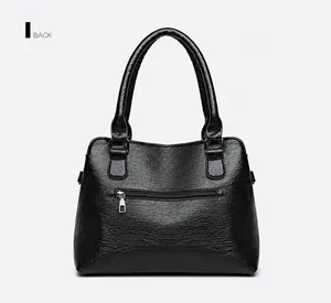 Detailed back view of a black leather tote bag with a functional horizontal zipper pocket