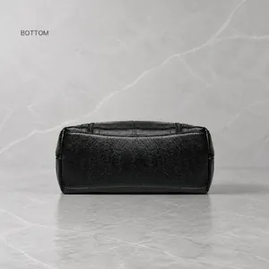 Macro detail of high-quality pebbled leather texture and reinforced double stitching on the bottom