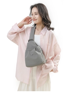 Close-up of grey waterproof nylon chest bag with silver logo and adjustable wide strap