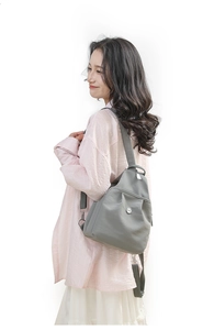 Detail showing grey nylon backpack with adjustable straps and side view silhouette