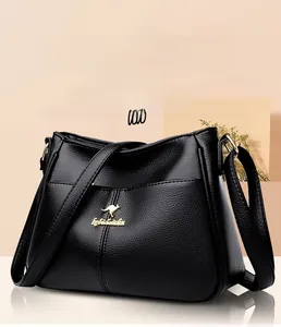 Close-up of black litchi pattern leather texture with gold kangaroo logo on crossbody bag