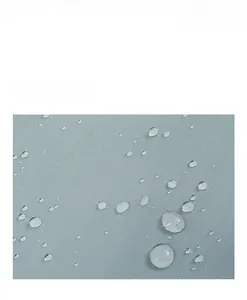 Detailed close-up of water-resistant nylon fabric with fine plaid texture and water droplets