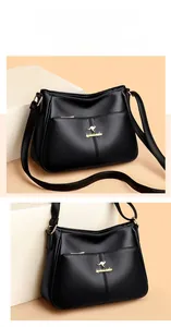 Close-up of black lychee leather texture and golden kangaroo logo on the shoulder bag