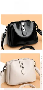 Detail view of smooth black and off-white shoulder bags with silver metal twist locks
