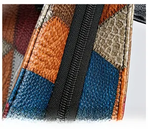 Close-up of smooth black metal zipper on multi-textured patchwork faux leather tote bag