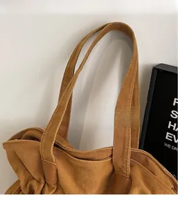 Detail of durable brown canvas tote with reinforced leather strap and zipper closure