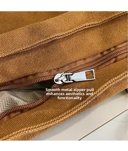 Detailed close-up of smooth silver metal zipper puller on a brown nylon bucket bag