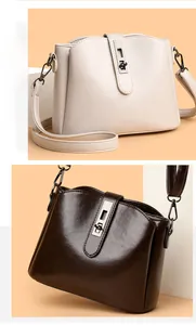Detail of minimalist cream and brown bucket bags with elegant metal clasps and PU leather