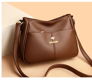 Close-up of brown litchi pattern leather texture and golden kangaroo logo on the handbag