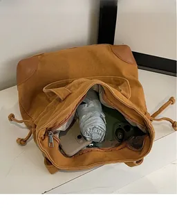 Spacious interior of brown canvas tote bag showing storage pockets and capacity