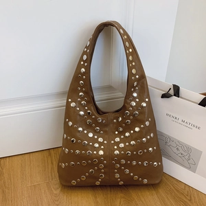Braune Punk-Hobo-Tasche aus Leder mit Nieten in einem minimalistischen Wohnambiente