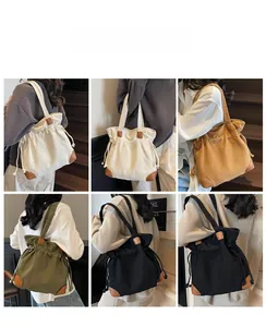 Detailed multi-color canvas drawstring tote bag collection shown on shoulder by model