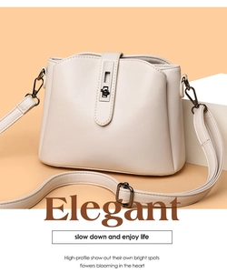 Detail of elegant cream leather crossbody bag with metal bar and black twist lock closure