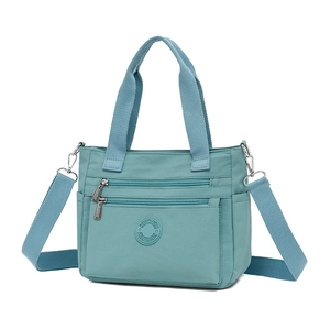 Large teal nylon tote bag with multi-layer pockets and adjustable shoulder strap