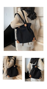 Détail du sac seau en nylon noir avec renforts en cuir marron et fermeture par cordon