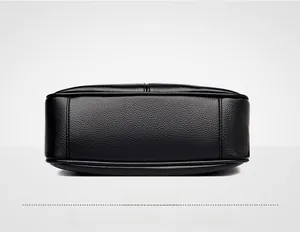 Detailed view of black lychee grain leather handbag base with reinforced stitching