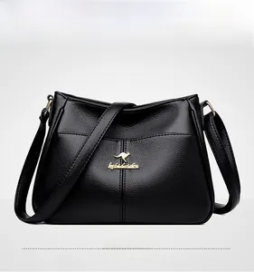 Detail of black lychee texture leather bag featuring golden kangaroo logo and adjustable strap