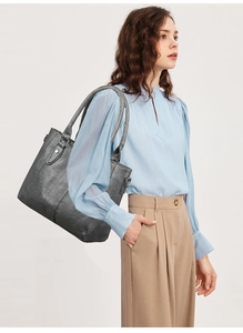 Dunkelgraue Shopper-Tasche aus Kunstleder getragen von Model für Business-Look